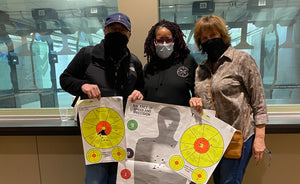 Black female gun instructor with husband and wife students and targets